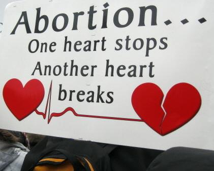 Banner says: 'Abortion...One heart stops/Another heart breaks'