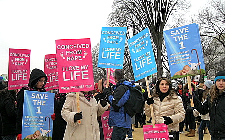 Marchers carry signs that say, 'Conceived from Rape/I Love My Life'