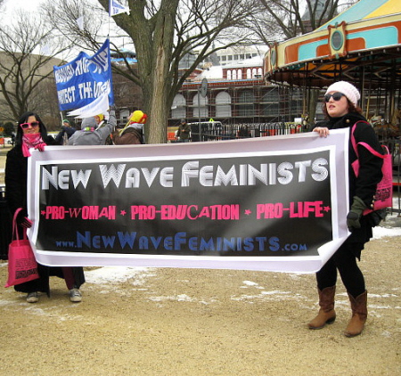 Two women hold 'New Wave Feminists' banner