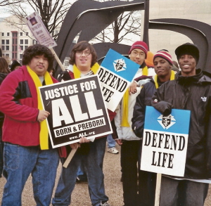 Five young men at March for Life with 
'Defend Life' and 'Justice for All' signs