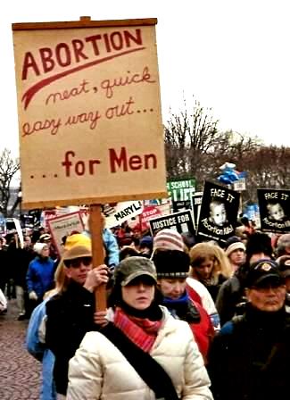 Man holds sign: 'ABORTION/neat, quick easy way out......for Men'