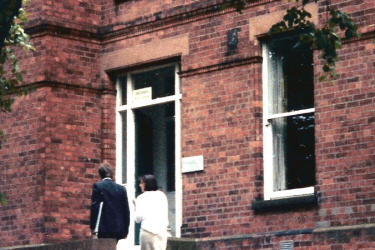 Two people at entrance to brick building
