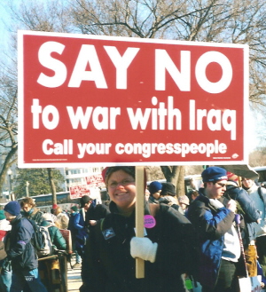 Woman holds sign: 'SAY NO to war with Iraq'