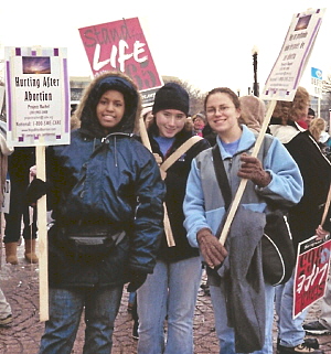 Three young women with pro-life signs